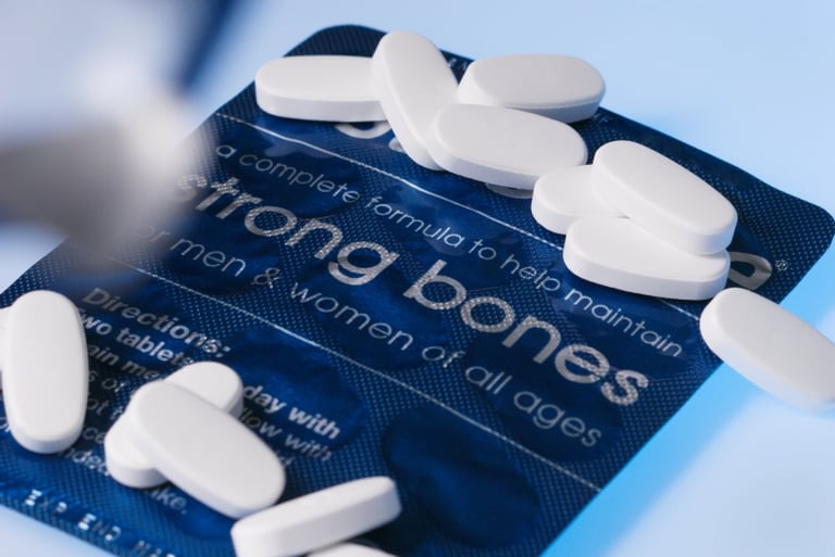 strong bones라고 적혀진 알약 패키지 위에 알약이 올려진 사진
